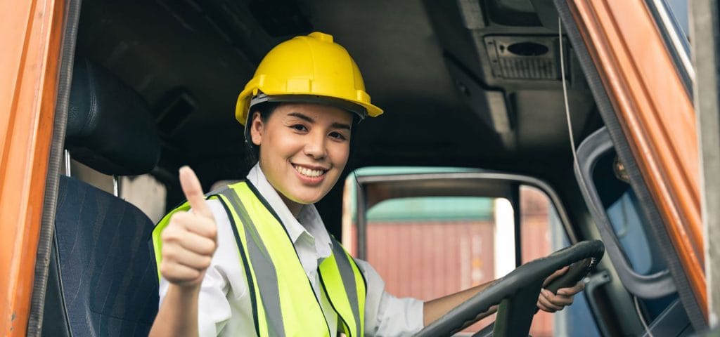 Female commercial driver with hardhat giving thumbs up - affordable DOT physical exams
